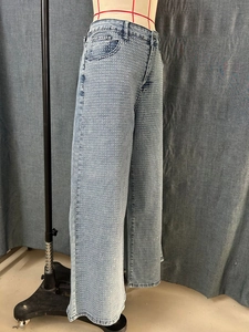 Detailed view of light blue straight denim jeans with sparkling silver rhinestone accents