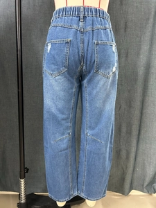 Detail of elastic waistband and distressed back pockets on blue wide-leg jeans
