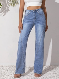 Detail of light blue high waist jeans featuring unique diagonal stitching and wide leg cut