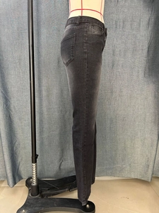 Side view of slim-fit flared black denim jeans with washed texture on mannequin