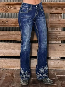 Detail of western-style embroidery and contrast stitching on dark blue bootcut jeans