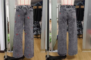 Detail view of cherry embroidery on grey snowflake wash wide-leg denim jeans
