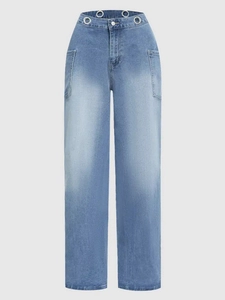 Detail of high waist light blue jeans featuring decorative silver metal grommets