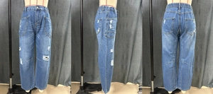 Detail view of baggy distressed jeans featuring elastic waist and knee rip design