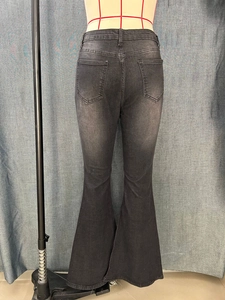 Rear view of slim fit flare jeans with back pockets and washed denim texture
