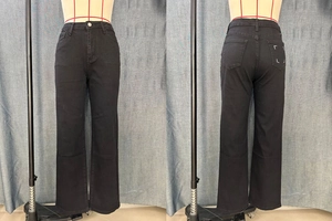 Détail d'un jean noir coupe droite avec coutures blanches en L sur la poche arrière