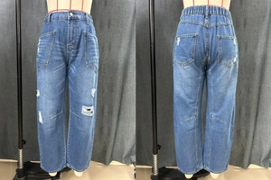 Detail of high waist distressed denim jeans featuring large cargo pockets and knee rips