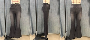 Detail of high-waisted flared jeans in dark grey featuring vintage washed texture and fit