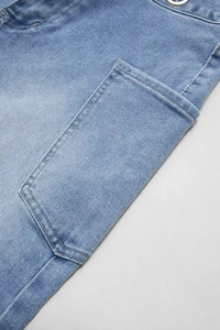 Detail of light blue wide-leg jeans showing a large side pocket and clean stitching