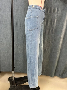 Detail of high waisted wide leg denim pants with metal eyelets and cargo style pockets