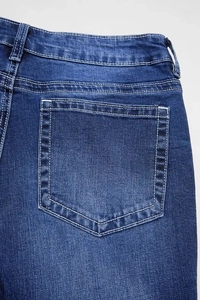 Detailed macro view of the back pocket on these dark blue washed denim flared jeans