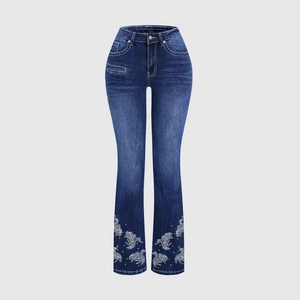 Deep blue flare jeans with vintage wash and delicate white embroidery at the leg opening
