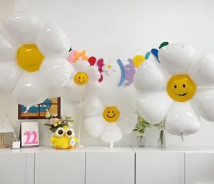 Detail view of white daisy foil balloons with yellow smiley faces for party decor