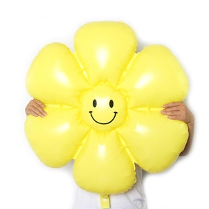 Large daisy foil balloon with smiley face held by model for party decoration