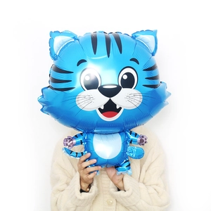 Blue cartoon tiger foil balloon for New Year decoration held by hands showing real size
