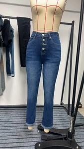 Detail of high waist dark blue jeans with four silver buttons and whiskers effect