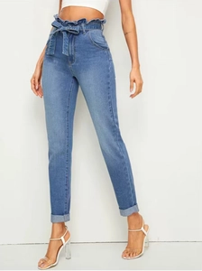 Detail of high waisted paperbag jeans with denim tie belt and stylish folded cuffs