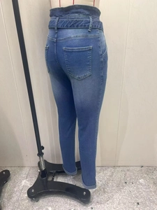 Detail view of high-waisted dark blue slim-fit jeans with a matching belt and rolled cuffs