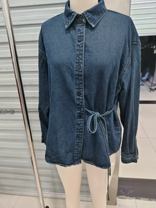 Détail de chemise en jean bleu foncé avec fermeture à boutons et cordon de serrage taille