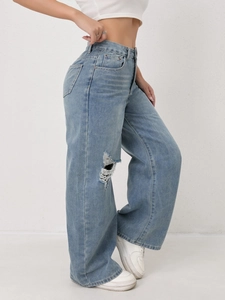 Close-up of light blue wide leg jeans featuring distressed ripped details and high waist fit