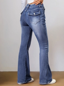 Détail macro du jean évasé bleu taille haute avec poches arrière à rabat et texture denim lavé