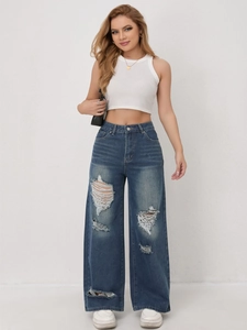 Detail van high waisted jeans met wijde pijpen, vintage wassing en modieuze scheuren