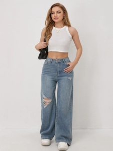 Detailed view of women's light blue wide-leg jeans with distressed knee holes and frayed edges