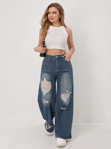 Detail van de blauwe jeans met hoge taille en wijde pijpen met modieuze knie-scheuren