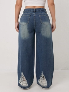 Detail van de gerafelde zoom en gescheurde effecten op wijde denim jeansbroek
