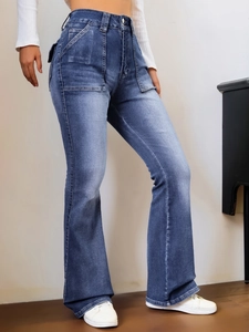 Détail du jean évasé délavé bleu à taille haute avec grandes poches plaquées devant