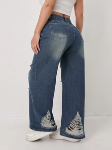 Detail van een wijde jeans met unieke ruitvormige scheuren aan de onderkant van de pijp