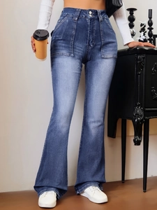 Détail du jean évasé à taille haute avec fermeture à double bouton et denim bleu délavé