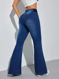 Detail view of high waist dark blue flare jeans with black elastic side waistband insert