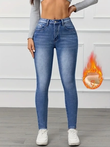 Detail of high-waist slim fit jeans in deep blue featuring warm thermal fleece lining