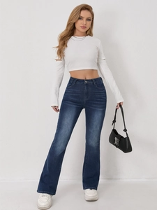 Détail du jean évasé à taille haute avec délavage classique et moustaches sur denim bleu foncé