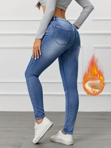 Detail of high-waist slim jeans with fleece lining icon showing warmth for winter