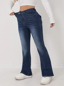 Détail du jean évasé extensible à taille haute montrant le délavage denim bleu foncé et la coupe