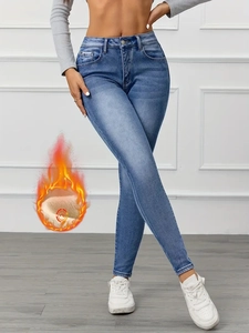Detail view of high-waist slim fit thermal jeans with soft fleece lining and warm blue wash