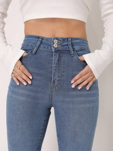 Detailed close-up of high waist blue jeans with trendy double button closure design