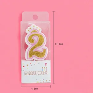Pink number 2 birthday candle with gold glitter and crown on pink background