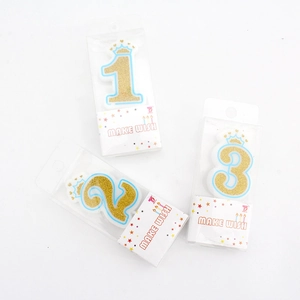 Golden glitter birthday candles with crowns 1 2 3 in blue trim on white background