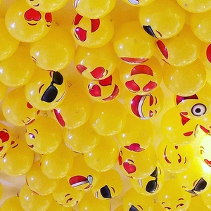 Group of 12-inch yellow latex balloons with various funny cartoon emoji faces for party decor