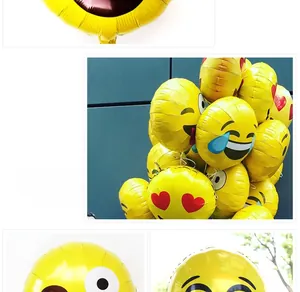 Detail of yellow emoji foil balloons featuring heart eyes and wink for party decoration