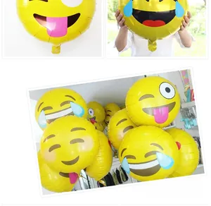 Detail view of yellow Emoji foil balloons for party decor with glossy finish