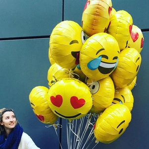 Bunch of yellow emoji foil balloons with heart eyes and smiles for birthday party decor
