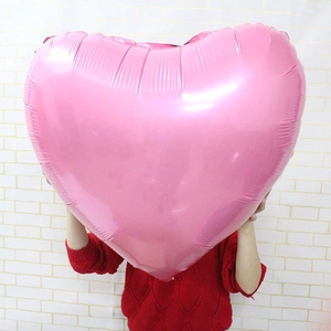 Large pink heart-shaped foil balloon held by a model for wedding and party decoration