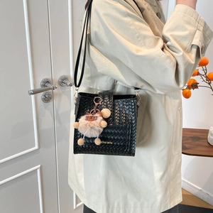 Retro black woven bucket bag for women with plush bear charm and thin shoulder strap