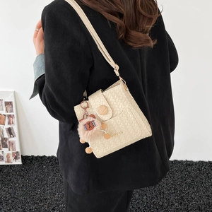 Retro cream woven bucket bag with wood buckle and plush ball charm on wide strap