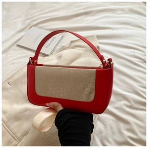 Detail of red leather and canvas box bag with contrast stitching and gold hardware