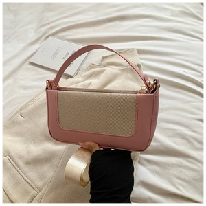 Detail of pink leather and beige fabric contrast shoulder bag with golden hardware